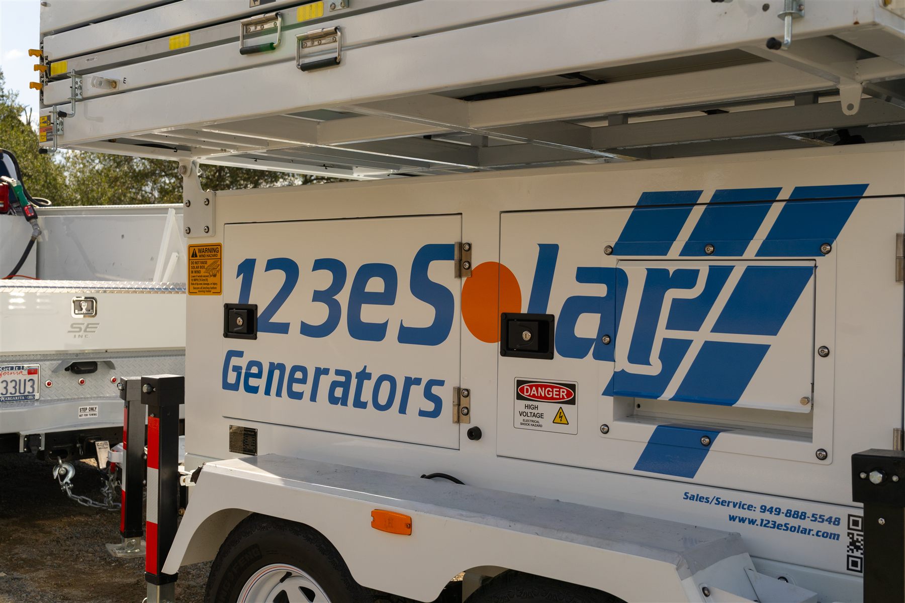 123-SG-4D41 — The enclosure up close beneath the folded array: the inverter and the 21.2 kWh bank ride inside.