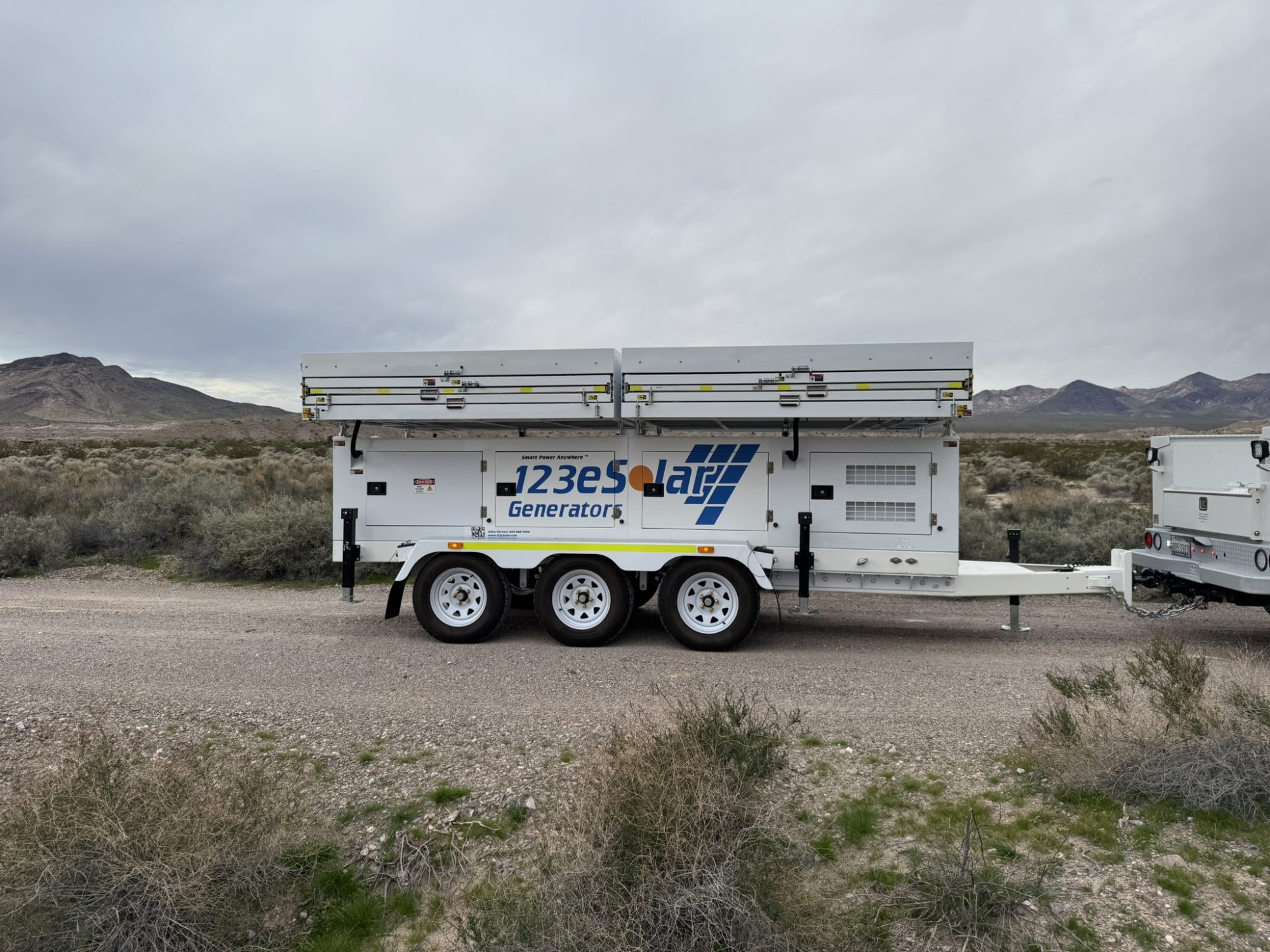 123-SG-7S42 — Sixteen panels folded into a triple-axle trailer, arriving on a desert site with no grid.
